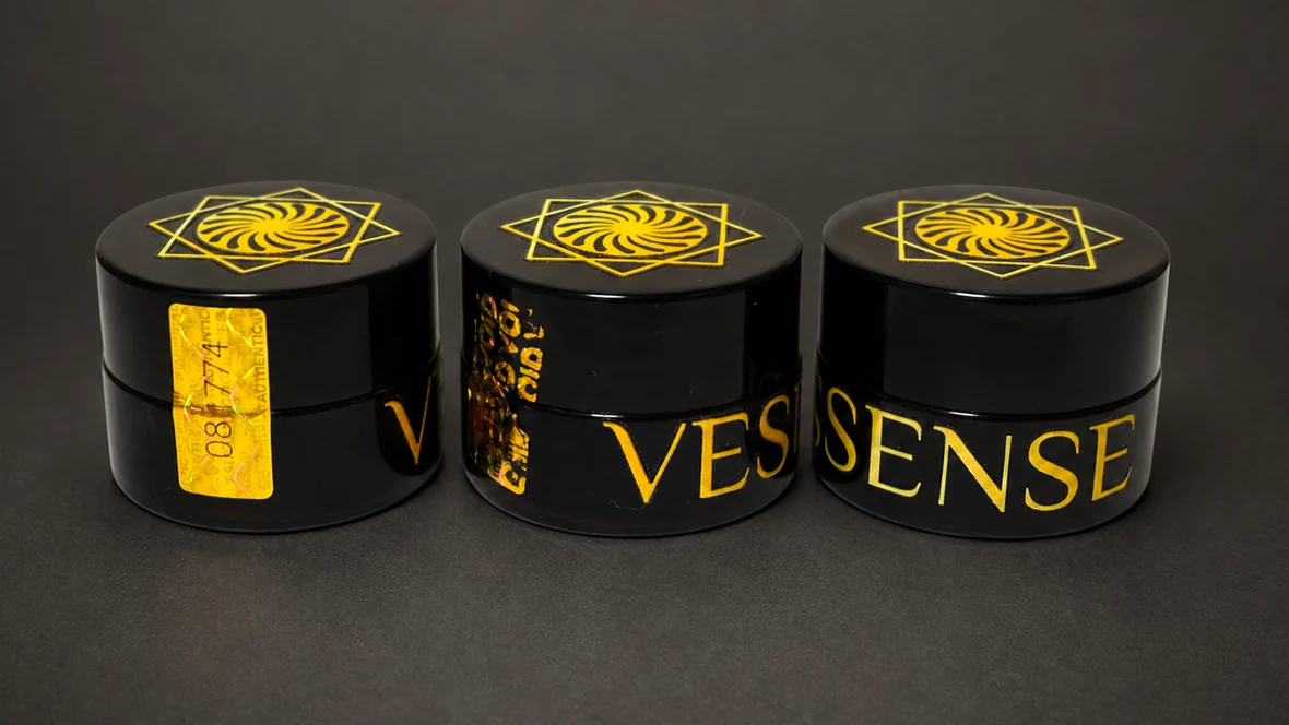 Three VESSENSE LE BAUME GRAND LARGE dark glass jars with gold branding and numbered holographic seals