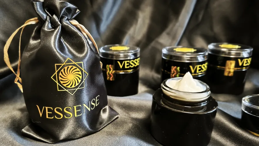 Glossy black glass VESSENSE jar with gold lettering, studio portrait